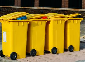 Normal_row-of-new-yellow-waste-containers-on-the-street-2023-03-01-02-58-07-utc