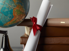 Normal_brown-books-globe-and-diploma-with-red-ribbon-on-2023-11-27-05-28-59-utc